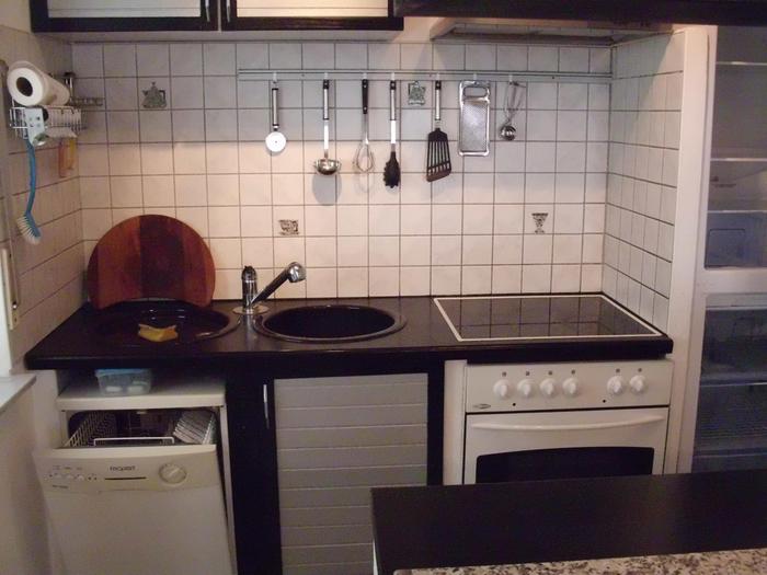Kleine Kochnische mit kleiner Einbauspülmaschine, Runder Spülbecken, Cerankochfeld und unten ein weißer Backofen
