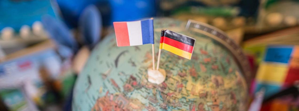 Erdkugel (Globus) mit zwei Länderfahnen (Frankreich und Deutschland)