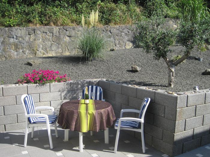 Foto von der Terrasse. Kleiner runder Beistelltisch mit drei passenden Gartenstühlen